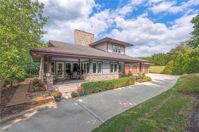 18402 W 64th St, Shawnee, KS 66218 - view of front of house with concrete driveway, stone siding, an attached garage, and a chimney