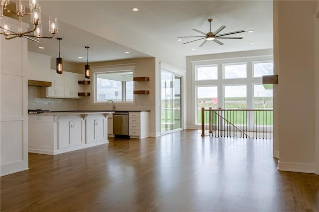 kitchen with decorative light fixtures, white cabinetry, wood-type flooring, decorative backsplash, and stainless steel dishwasher