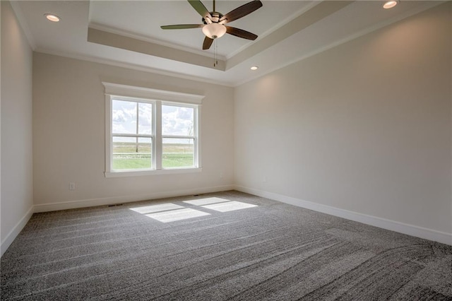 carpeted spare room with crown molding, ceiling fan, and a tray ceiling