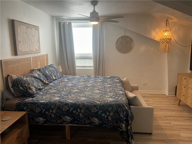 bedroom featuring baseboards, light wood finished floors, and ceiling fan