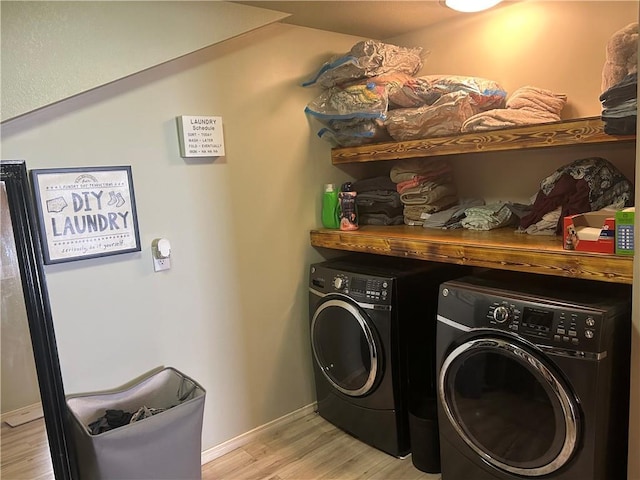 clothes washing area featuring laundry area, baseboards, light wood-style flooring, and washing machine and dryer