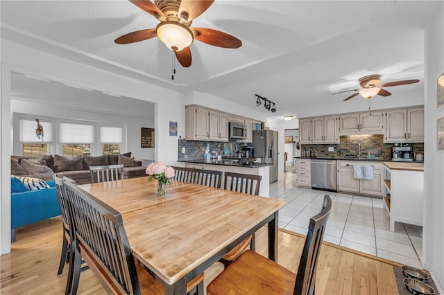 dining room with ceiling fan, sink, and light hardwood / wood-style floors