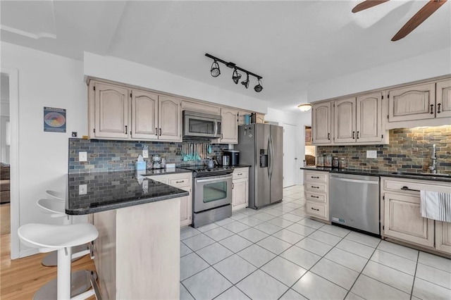 kitchen with sink, decorative backsplash, stainless steel appliances, and a kitchen bar