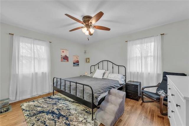 bedroom featuring multiple windows, ceiling fan, and light wood-type flooring