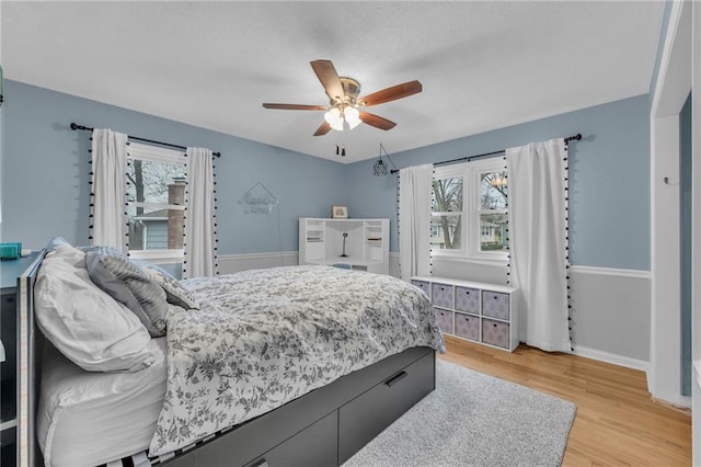 bedroom featuring multiple windows, ceiling fan, and light hardwood / wood-style floors