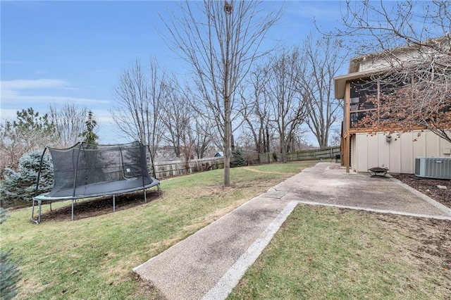 view of yard featuring a trampoline, central air condition unit, and a patio area