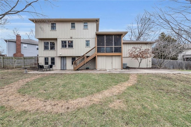 rear view of property with central AC unit, a patio area, a sunroom, and a lawn