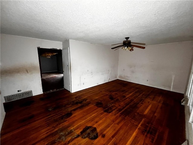 spare room featuring ceiling fan, a textured ceiling, and dark hardwood / wood-style flooring