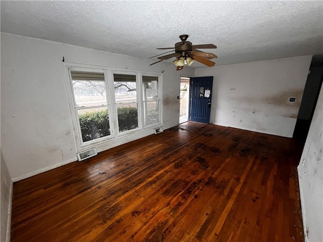 unfurnished room featuring ceiling fan, a textured ceiling, and dark hardwood / wood-style flooring