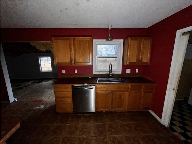 kitchen with stainless steel dishwasher, sink, and a textured ceiling