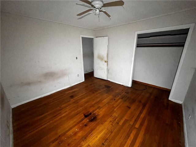 unfurnished bedroom with dark wood-type flooring, a closet, and ceiling fan