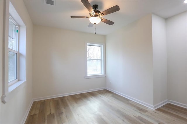 spare room featuring light wood-style floors, visible vents, and baseboards