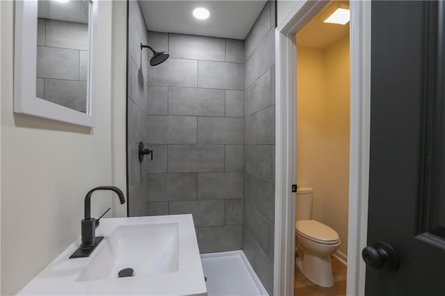 full bath with a sink, a shower stall, and toilet