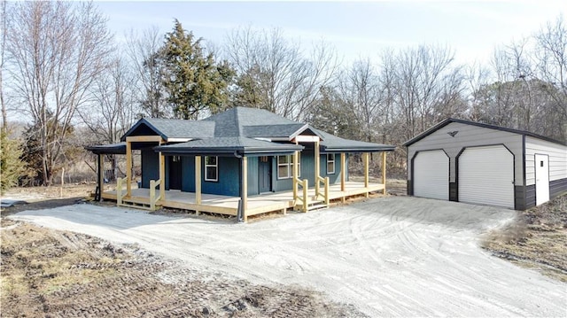 view of front of property with a garage, roof with shingles, a porch, and an outbuilding