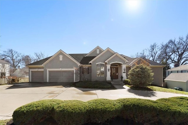 view of front facade with a garage, concrete driveway, and stucco siding