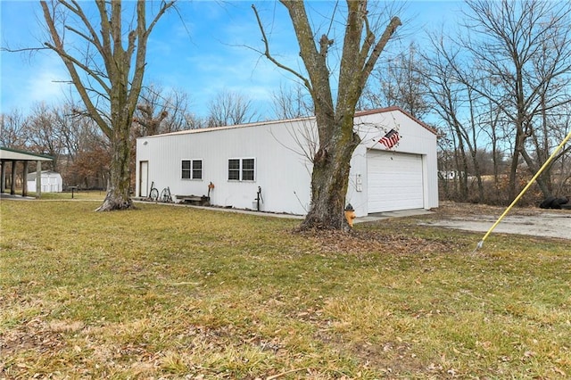 view of front of home with a garage, an outdoor structure, and a front yard