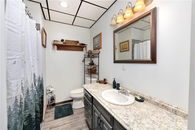 bathroom with hardwood / wood-style flooring, a paneled ceiling, vanity, a shower with curtain, and toilet