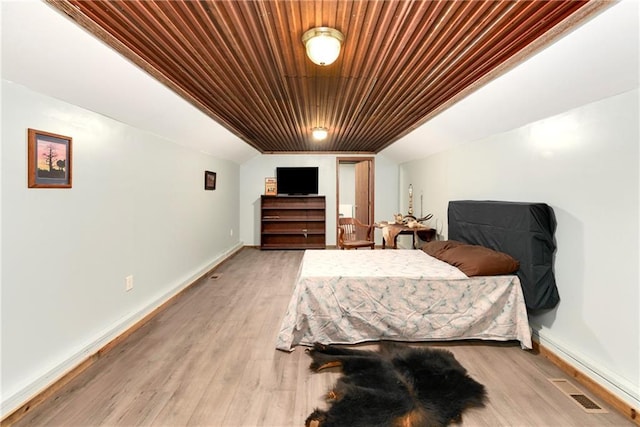 bedroom featuring lofted ceiling, wood ceiling, and light wood-type flooring