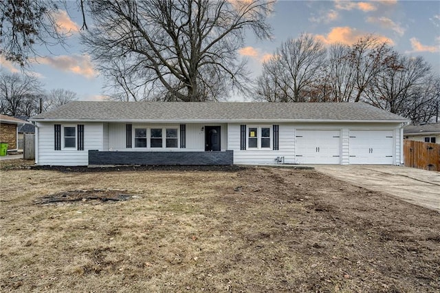 single story home featuring a garage and a lawn