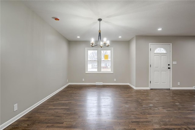 entryway featuring an inviting chandelier and dark hardwood / wood-style flooring