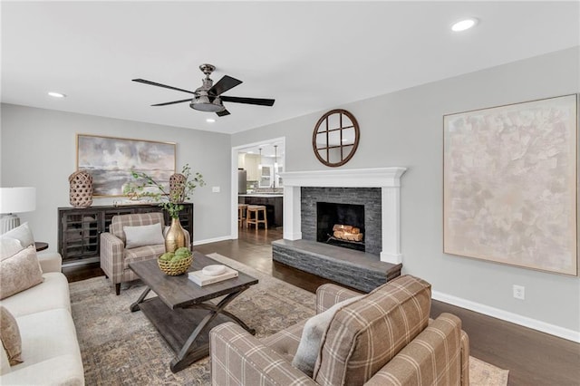 living room with dark hardwood / wood-style flooring, a fireplace, and ceiling fan