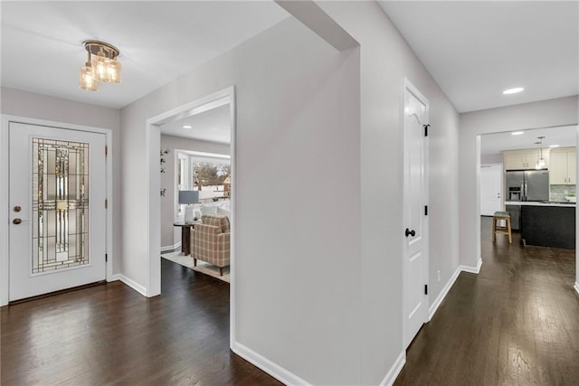 foyer with recessed lighting, dark wood finished floors, and baseboards