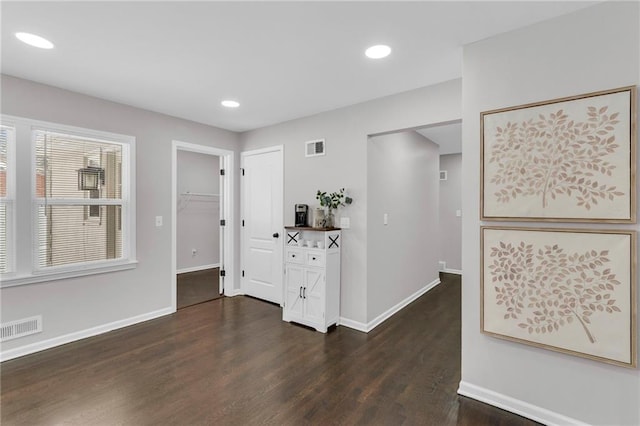 interior space with baseboards, visible vents, dark wood finished floors, and recessed lighting