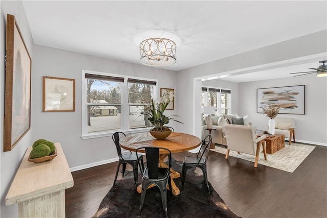 dining area with a notable chandelier, baseboards, and dark wood-style flooring