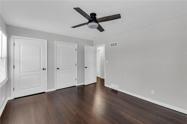 unfurnished bedroom with a ceiling fan, baseboards, visible vents, and wood finished floors