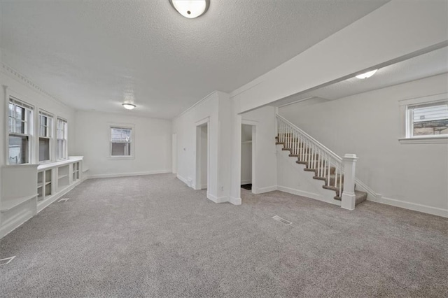 basement featuring a textured ceiling and carpet flooring