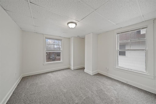 carpeted empty room featuring a paneled ceiling