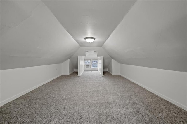 additional living space with vaulted ceiling and carpet floors