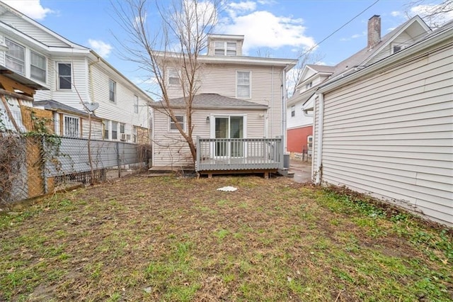 rear view of property featuring a wooden deck and a yard