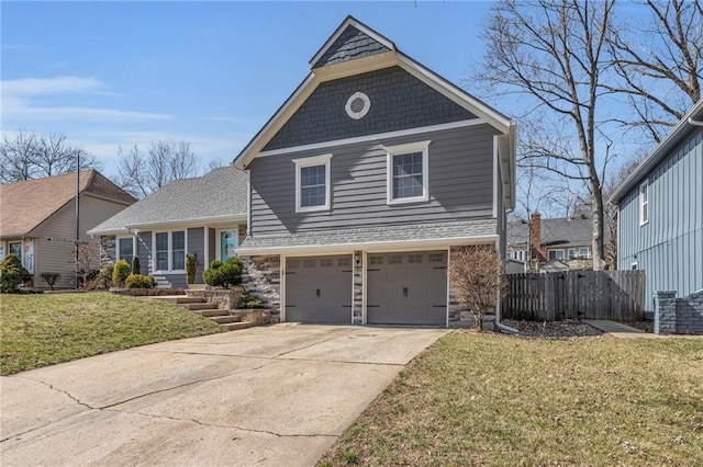 tri-level home featuring a front lawn, fence, driveway, stone siding, and an attached garage