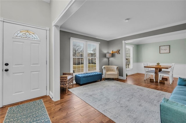 entryway featuring wood finished floors, baseboards, and ornamental molding