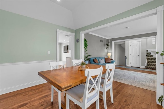 dining area with ornamental molding, lofted ceiling, baseboards, and hardwood / wood-style flooring