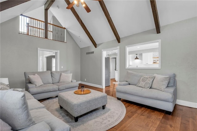 living room featuring visible vents, beamed ceiling, high vaulted ceiling, wood-type flooring, and ceiling fan