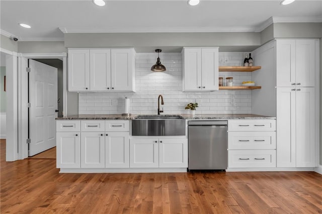 kitchen featuring light wood finished floors, a sink, dark stone countertops, and stainless steel dishwasher