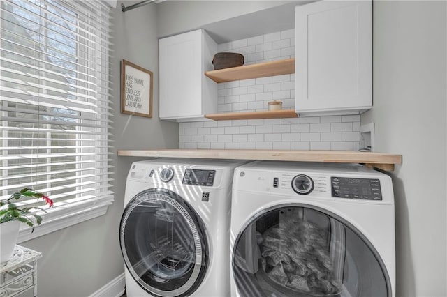 clothes washing area with cabinet space and independent washer and dryer