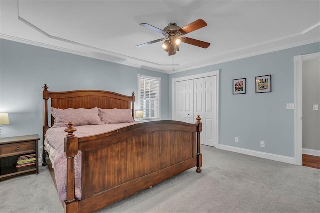 bedroom with baseboards, ceiling fan, a closet, crown molding, and carpet flooring