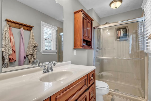 full bathroom featuring toilet, a stall shower, and vanity