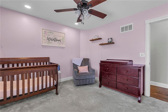 carpeted bedroom featuring recessed lighting, visible vents, baseboards, and a nursery area