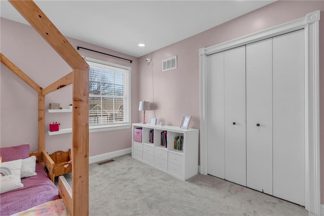 bedroom with light carpet, visible vents, baseboards, and a closet