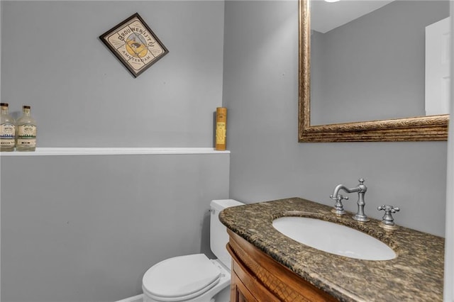 half bathroom featuring toilet and vanity