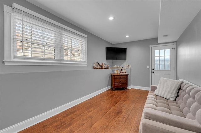 living area featuring recessed lighting, visible vents, baseboards, and wood-type flooring