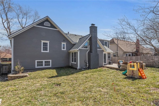 rear view of house with a patio area, a yard, fence, and a chimney