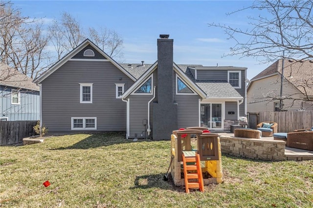 rear view of house featuring a lawn, a patio, fence, a fire pit, and a chimney