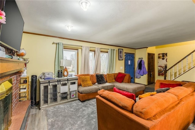 living room with crown molding, hardwood / wood-style floors, and a brick fireplace