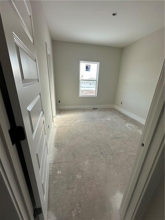 unfurnished room with baseboards