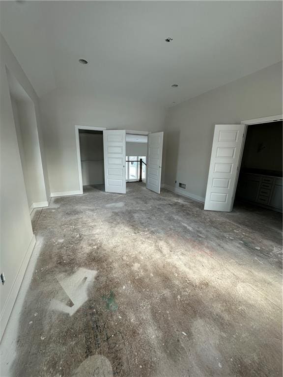 unfurnished bedroom featuring lofted ceiling and baseboards